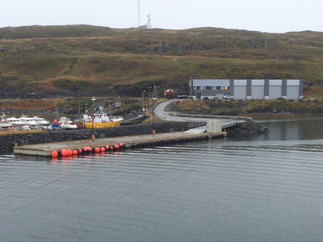 A harbour with a long quay and a building on the shore