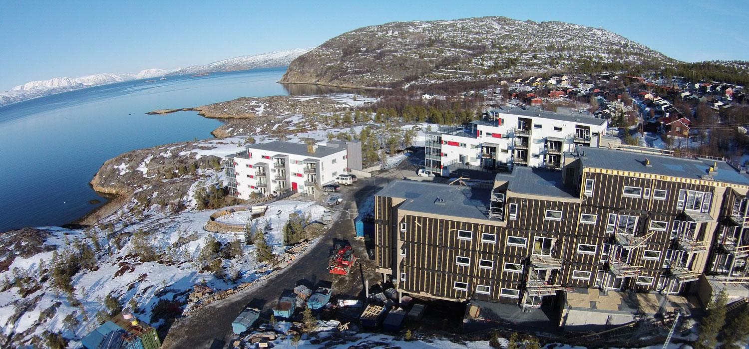 Aerial view of new blocks of flats on a hillside above the Alta fjord, with snow on the ground