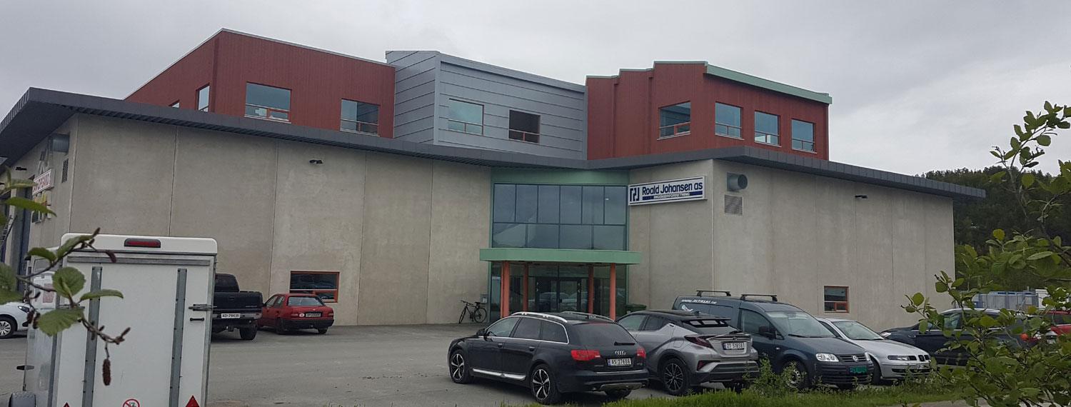 Their own office building in Humleveien: grey and red cladding, cars parked in front