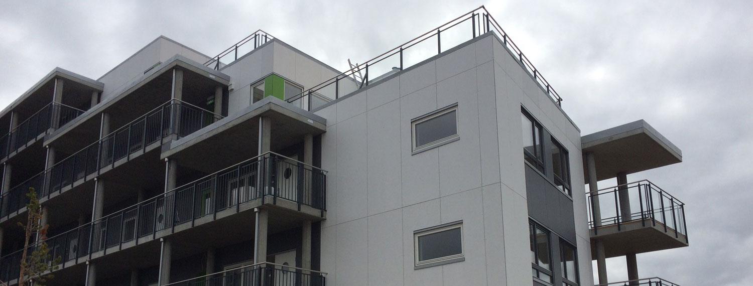A grey block of flats with deep balconies
